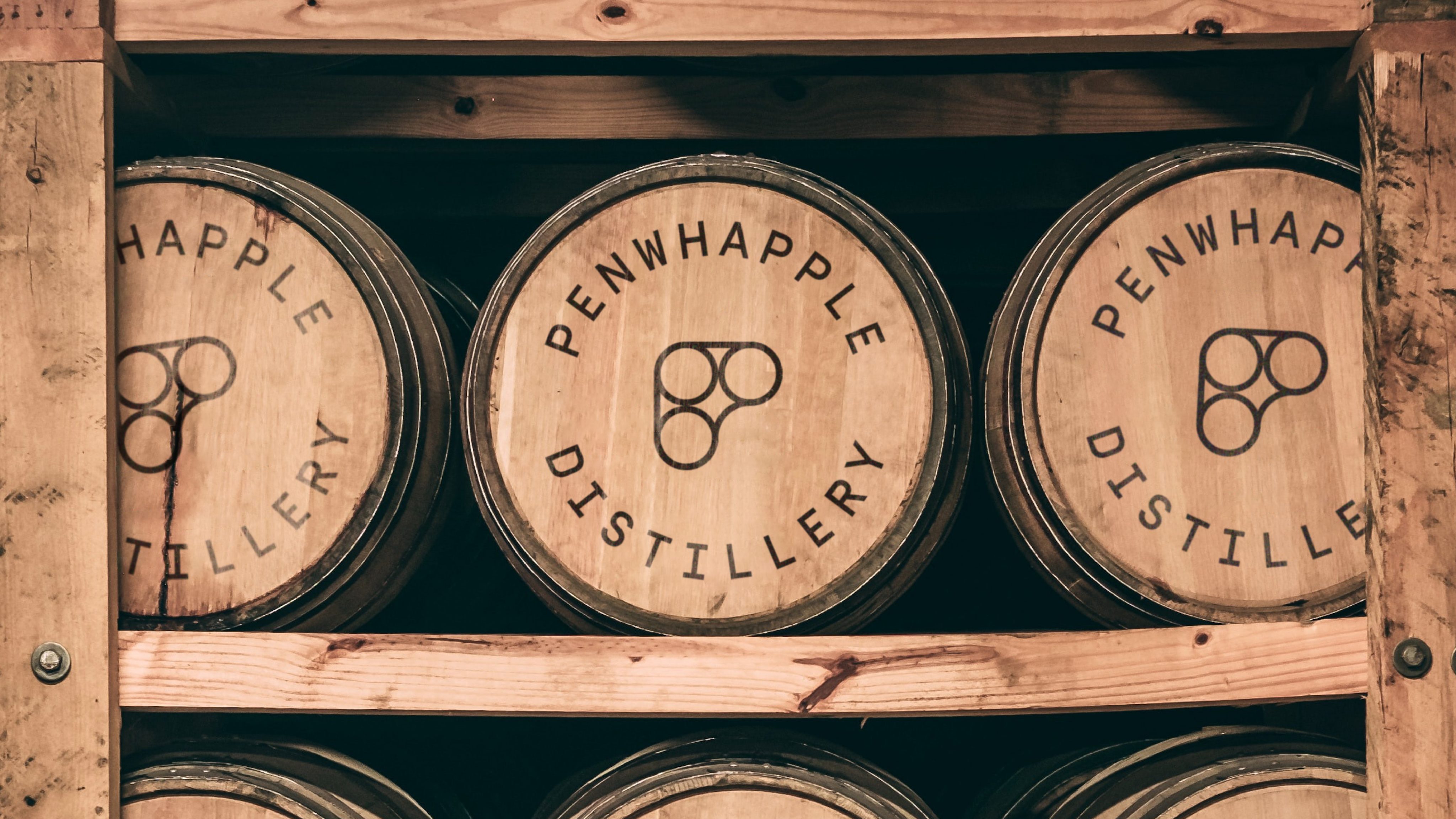 Wooden barrels with the distillery logo on them